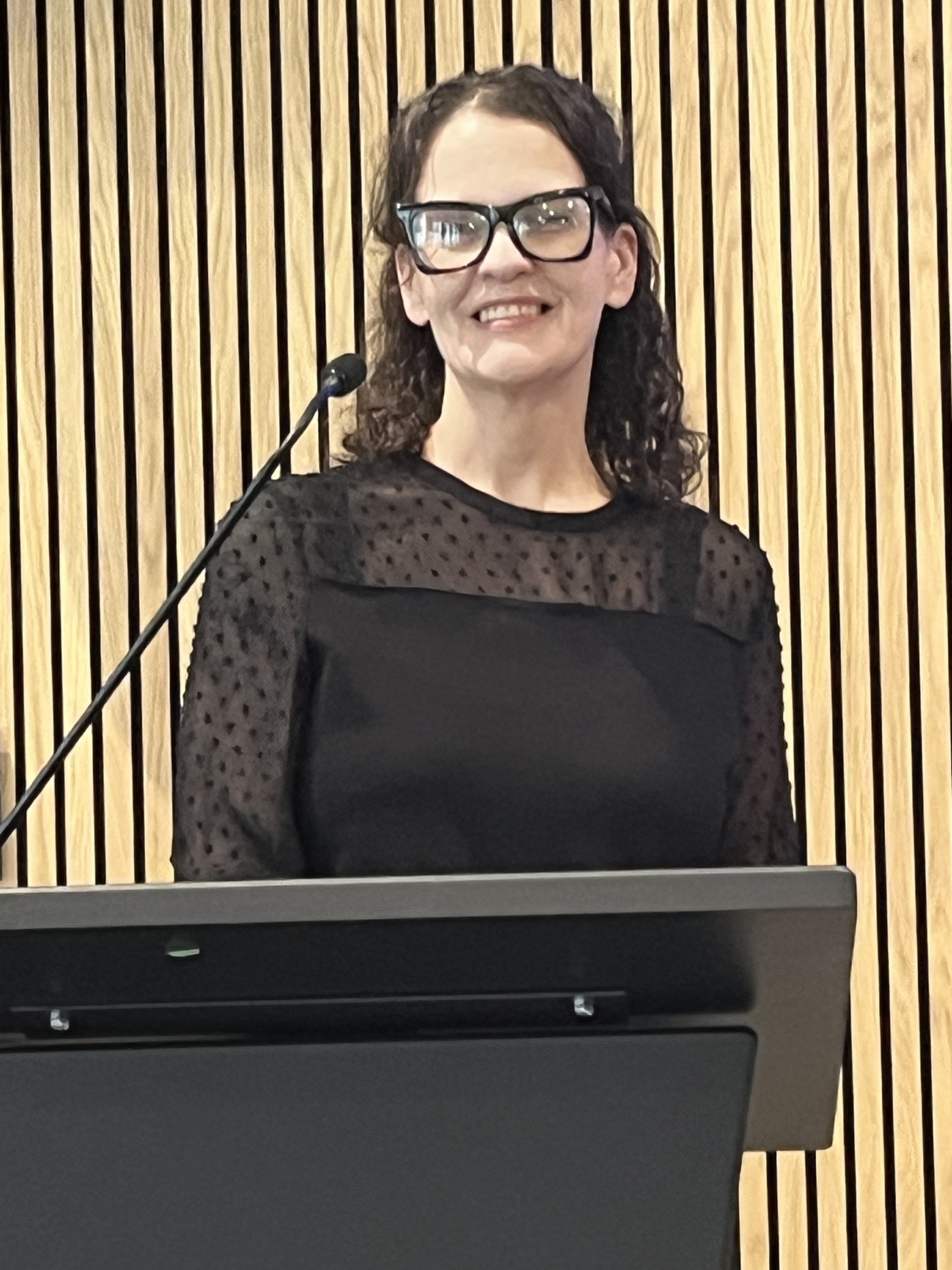 Dr. Payne speaking at a conference podium